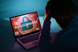 Image illustrant la prévention contre les ransomwares, avec un ordinateur affichant un cadenas et le mot «RANSOMWARE» sur l'écran.